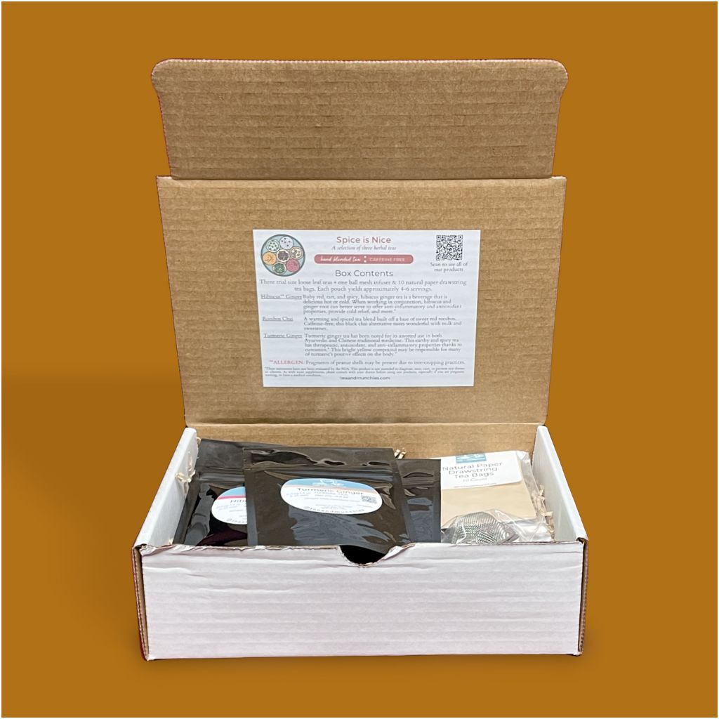Inside of Spice is Nice Tea Gift Set Box showing contents on a burnt orange background. Underside of box lid has a sticker outlining box contents | tea + munchies