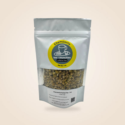 A stand-up pouch of chamomile herbal tea with a clear window showing the loose tea inside. The packaging is white with a circular yellow and dark green label reading 'Chamomile tea + munchies caffeine free'.