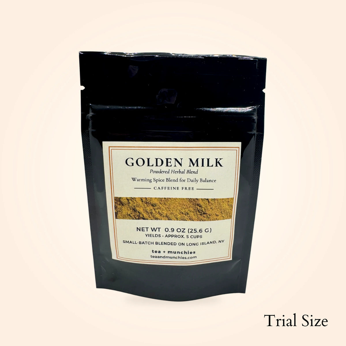 tea + munchies Golden Milk blend in a trial-size black pouch on a warm neutral background