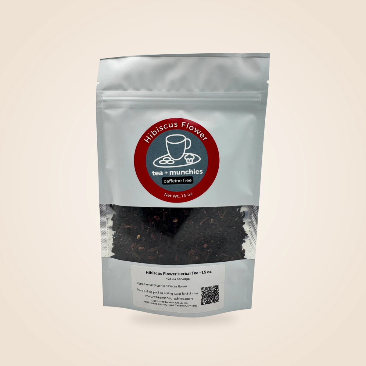 A white stand-up pouch of Hibiscus Flower Caffeine Free Herbal Tea by tea + munchies, featuring a clear window showing dark herbal tea leaves inside, set against a solid light beige background.