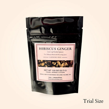 A black resealable stand-up pouch of Hibiscus Ginger herbal infusion tea with a white label, shown on a light beige background with the text 'Trial Size' in the bottom right corner.