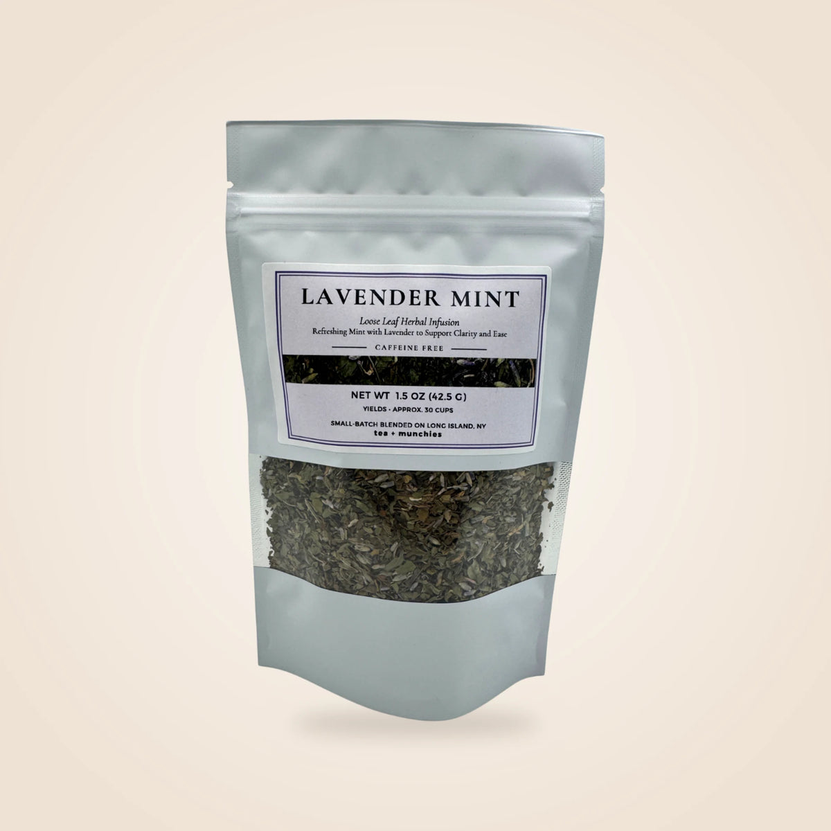 A white stand-up pouch of Lavender Mint herbal tea with a clear window showing the dark herbal blend inside, set against a solid light beige background.
