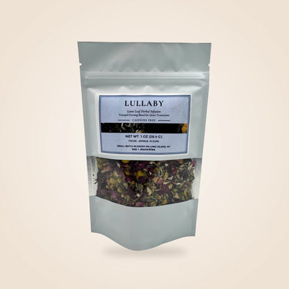 A white stand-up pouch of Lullaby herbal tea with a clear window showing dried herbs and flowers inside, set against a solid beige background.