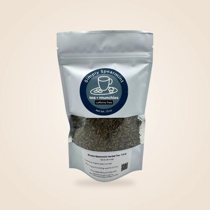 Simply Spearmint Caffeine Free herbal tea in a white stand-up pouch with a clear window showing the loose leaf tea inside, set against a solid light beige background.