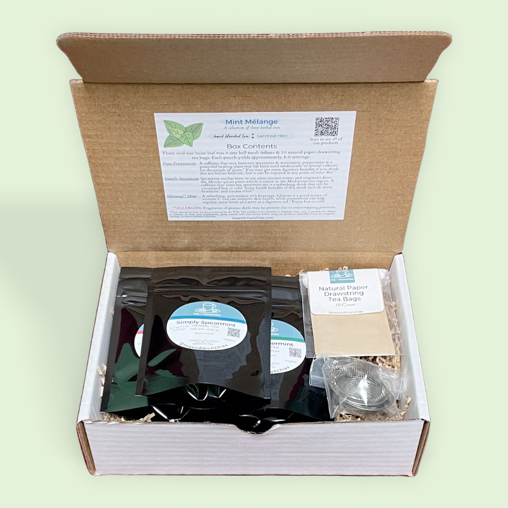 Inside of Mint Mélange Tea Gift Set Box showing contents on a light green background. Underside of box lid has a sticker outlining box contents | tea + munchies