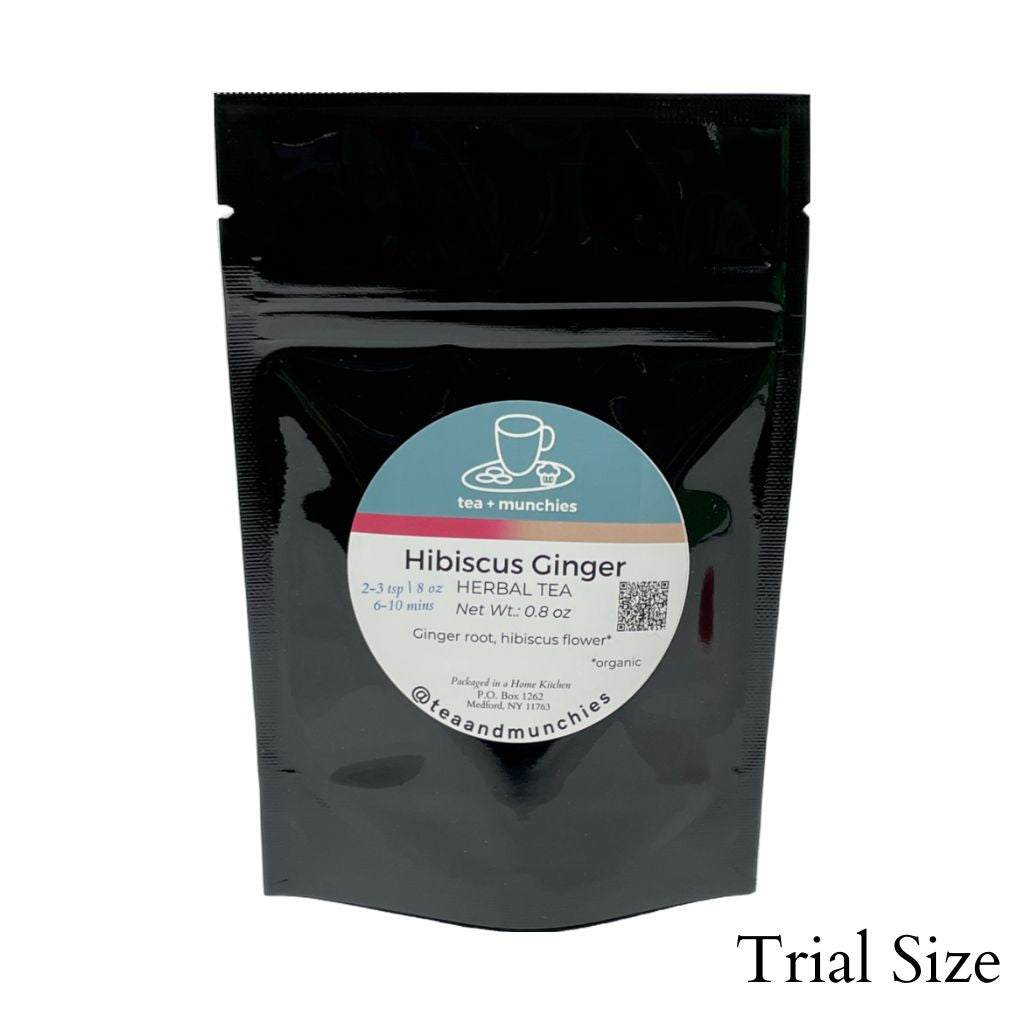 Resealable black glossy stand-up trial size package of loose leaf hibiscus ginger herbal tea on white background. 'Trial size' written in lower right hand corner | tea + munchies