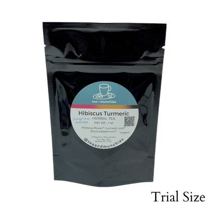 Resealable black glossy stand-up trial size package of loose leaf hibiscus turmeric herbal tea on white background. 'Trial size' written in lower right hand corner | tea + munchies